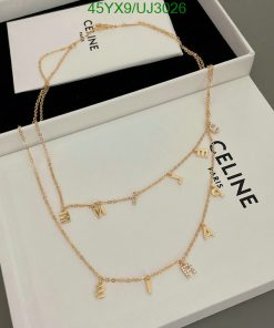 Celine gold letter charm necklace on display box.