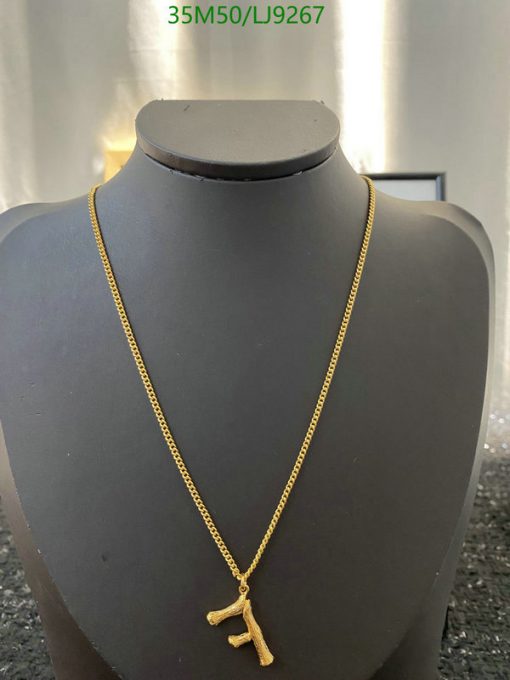 Gold necklace with pendant on mannequin display.