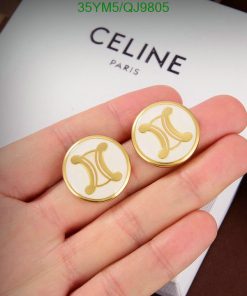 Gold designer logo cufflinks held over brand box.