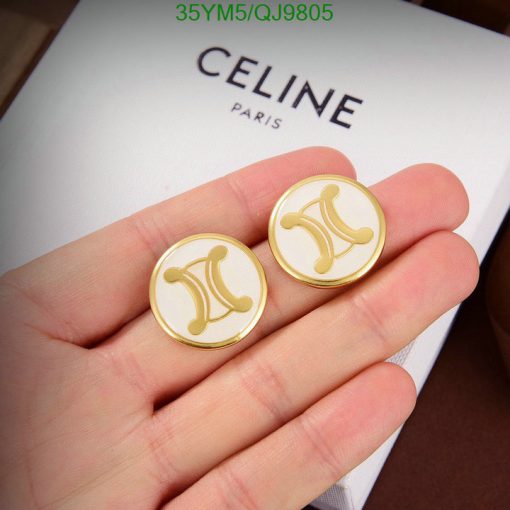 Gold designer logo cufflinks held over brand box.