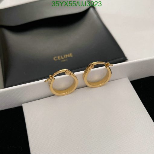 Gold hoop earrings on white display with Celine box.