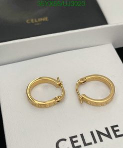 Gold hoop earrings on white display with luxury branding.