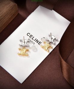 Elegant Celine Paris earrings on white display with brown ribbon.