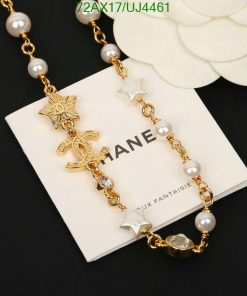 Gold chain bracelet with pearls and charms on display.