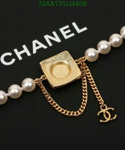 Gold square pendant with chain on pearl necklace.