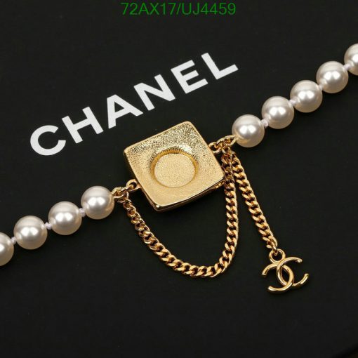 Gold square pendant with chain on pearl necklace.