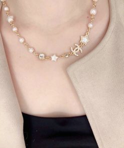 Woman wearing pearl and star necklace.