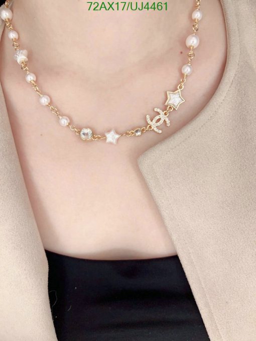 Woman wearing pearl and star necklace.