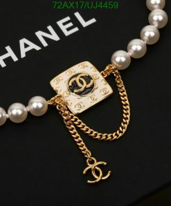 Gold designer logo brooch with pearl chain.