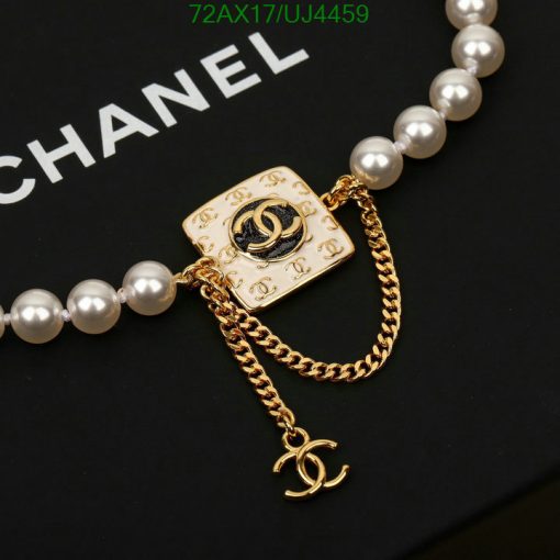 Gold designer logo brooch with pearl chain.