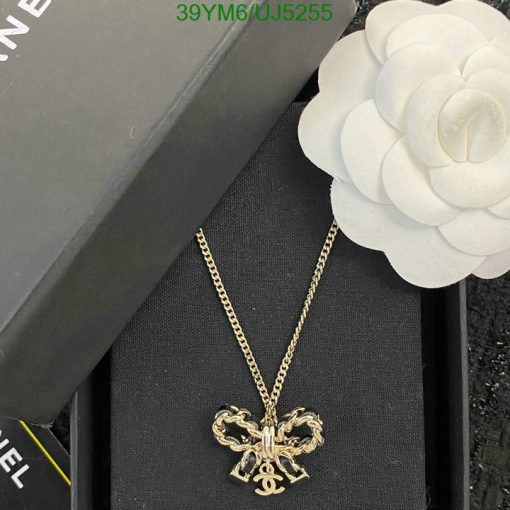 Designer gold pendant necklace with flower accessory.