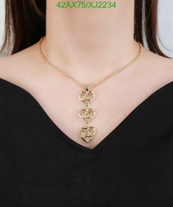 Gold heart pendant necklace on woman.