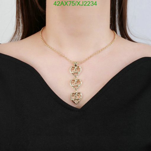 Gold heart pendant necklace on woman.