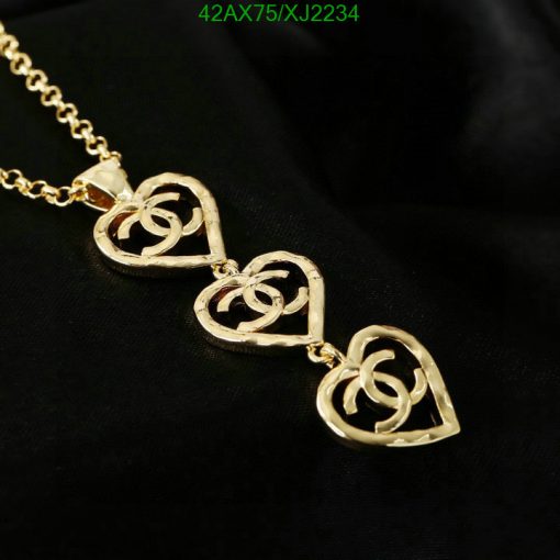 Gold heart pendant necklace on black background.