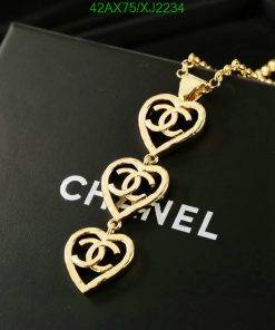 Gold heart-shaped pendant necklace on black surface.