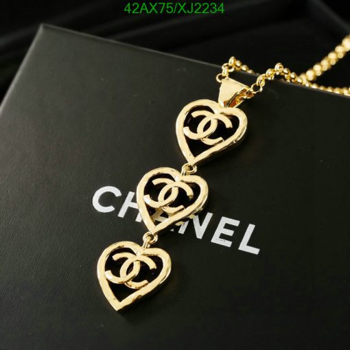 Gold heart-shaped pendant necklace on black surface.