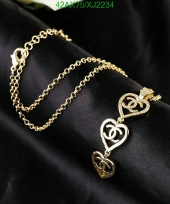 Gold heart-shaped charm bracelet on black fabric.