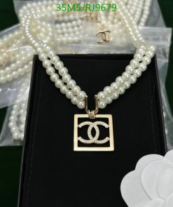 Elegant pearl necklace with pendant on black background.