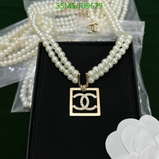 Elegant pearl necklace with pendant on black background.