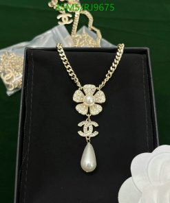 Gold floral pendant necklace with pearl detail on display.