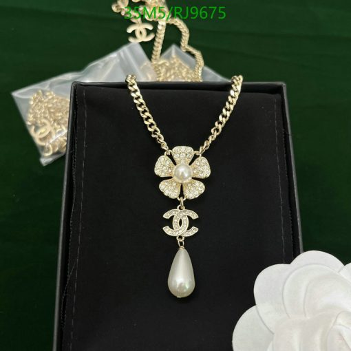 Gold floral pendant necklace with pearl detail on display.