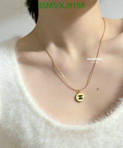 Person wearing a designer pendant necklace.