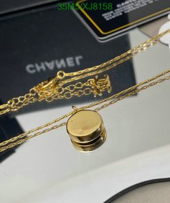 Gold pendant necklace on display with branded background.