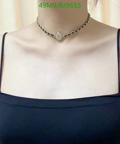 Woman wearing silver necklace with pendant.