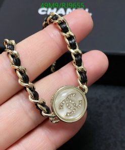 Gold bracelet with gemstone charm and black accents.