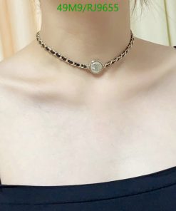 Silver pendant necklace on woman's neck.