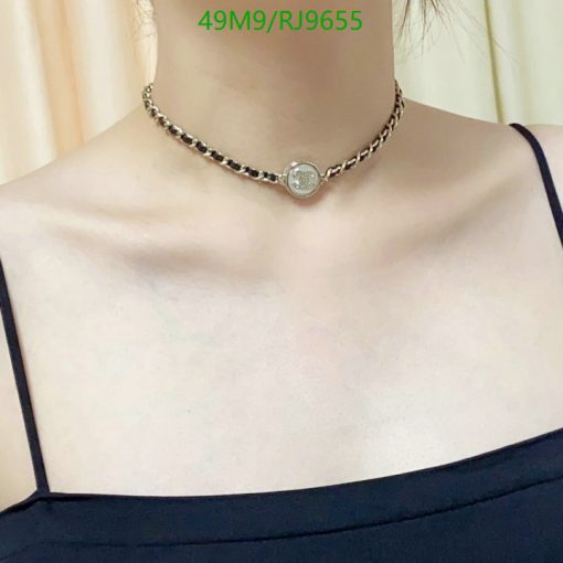 Silver pendant necklace on woman's neck.