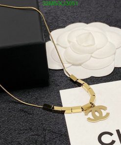 Gold designer logo necklace on display with box.