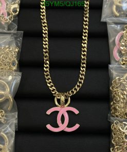 Gold necklace with pink pendant on black display.