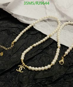 Elegant pearl necklace with gold accents on black paper.