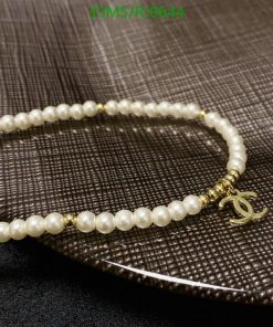 Elegant pearl necklace with gold accent on textured surface