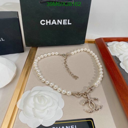 Chanel pearl necklace with logo pendant on display.