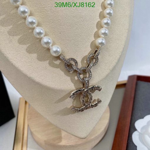 Pearl necklace with sparkling pendant on display stand.