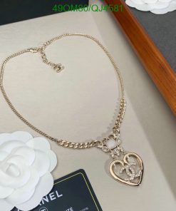 Gold necklace with heart pendant displayed on table.