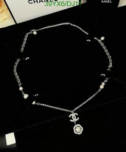 Silver necklace with pearls on black background.