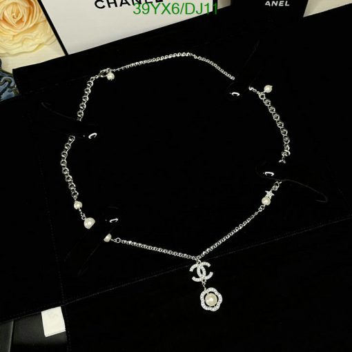 Silver necklace with pearls on black background.