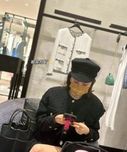 Woman in boutique using smartphone.