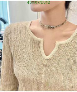 Woman wearing gold knit sweater and choker necklace.