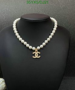 Elegant pearl necklace with anchor pendant on black display.