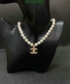 Elegant pearl necklace with pendant on black display stand.