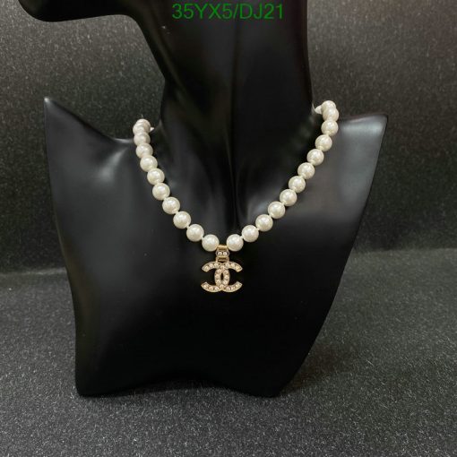 Elegant pearl necklace with pendant on black display stand.