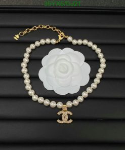 Pearl bracelet with flower and anchor charm on black background.