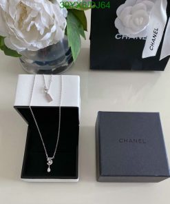 Elegant necklace in box with Chanel packaging and white flower.