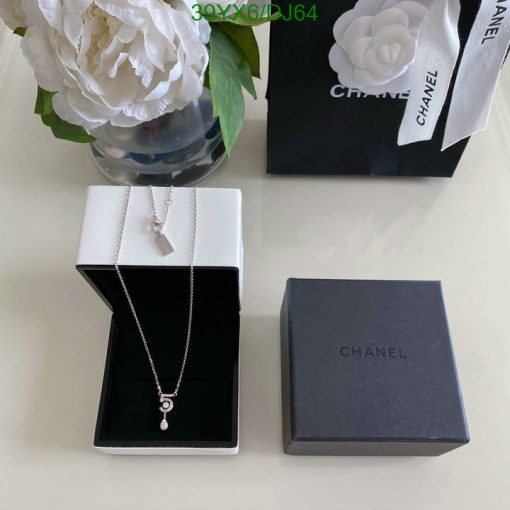 Elegant necklace in box with Chanel packaging and white flower.