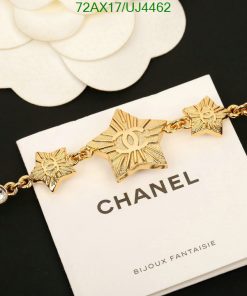 Gold Chanel star bracelet on white display.