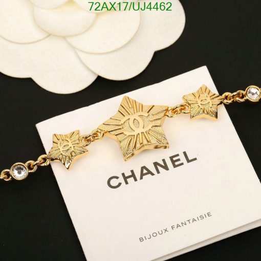 Gold Chanel star bracelet on white display.